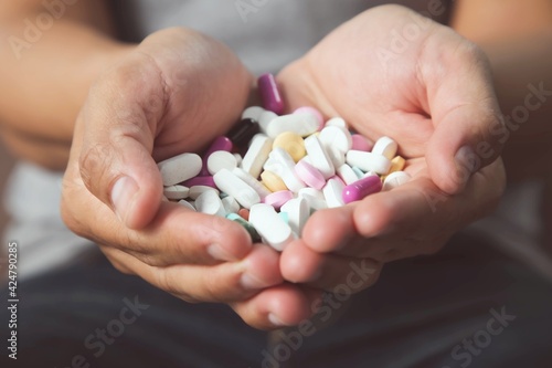 A wide variety of medicines pills and capsules were in the hands of young men.health care concept.