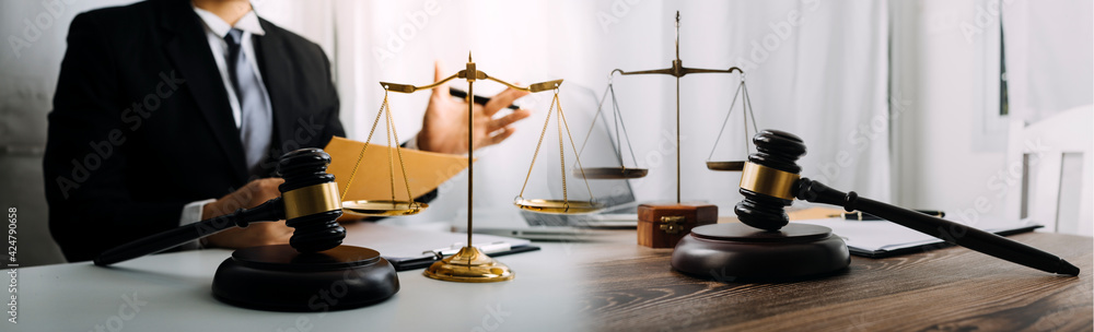 Business and lawyers discussing contract papers with brass scale on desk in office. Law, legal services, advice, justice and law concept picture with film grain effect Business and lawyers discussing contract papers with brass scale on desk in office. Law, legal services, advice, justice and law concept picture with film grain effect