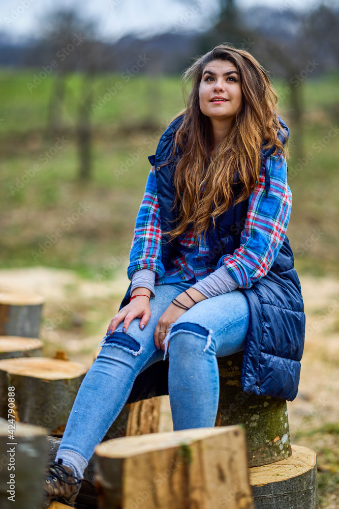 Obraz premium woman woodcutter rests on a log after hard work