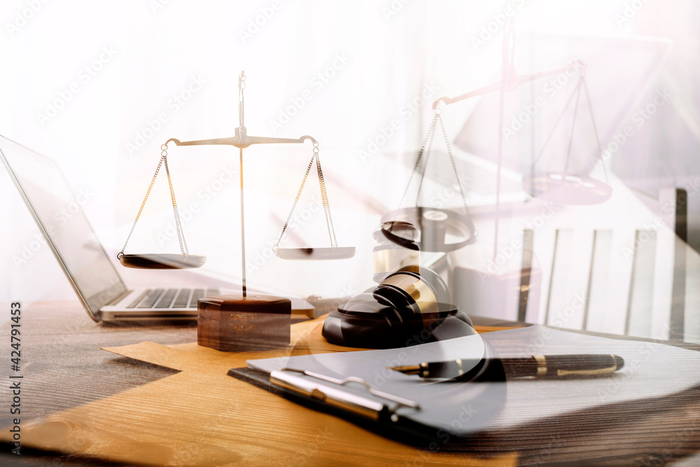 Business and lawyers discussing contract papers with brass scale on desk in office. Law, legal services, advice, justice and law concept picture with film grain effect Business and lawyers discussing contract papers with brass scale on desk in office. Law, legal services, advice, justice and law concept picture with film grain effect
