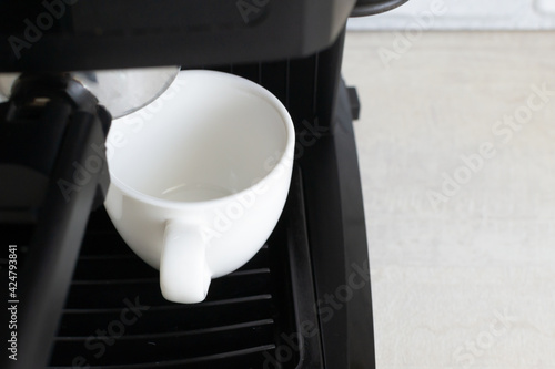 Black coffee machine and two white espresso cups. Homemade coffee making concept. Horizontal orientation. Close-up.