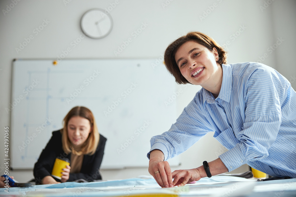 Smiling lady looking into camera while outlining fabric Smiling lady looking into camera while outlining fabric