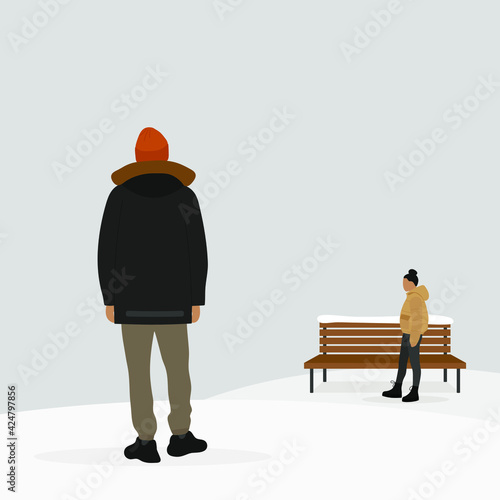 A male character in a jacket and a hat stands in the snow and looks into the distance, where is a wooden bench and a female character in a jacket