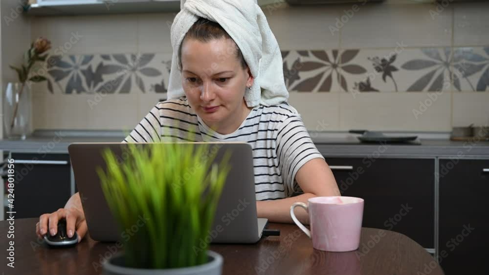 Womain working on laptop at home. Working online from home concept. Woman drying hair with towel Womain working on laptop at home. Working online from home concept. Woman drying hair with towel