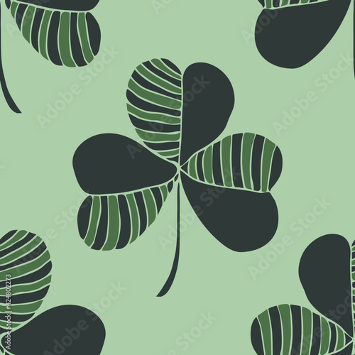 Seamless vector pattern with clover leaf on grey background. Simple artistic charm wallpaper design. Decorative luck fashion textile.