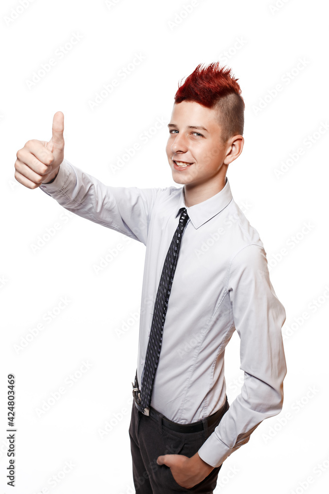 A smiling teenager shows his thumb up isolated on the white background A smiling teenager shows his thumb up isolated on the white background