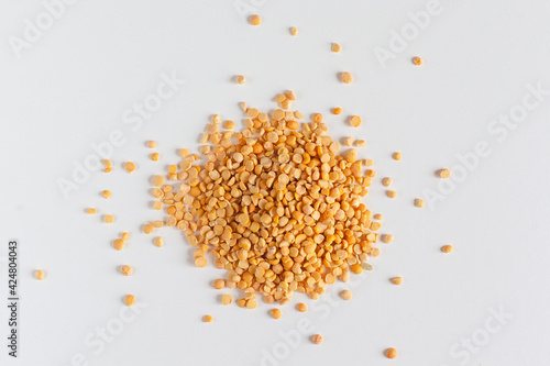 Slika na platnu Closeup of heap of yellow chana split peas isolated against white