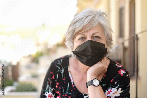 Senior woman with protective face mask looking at camera