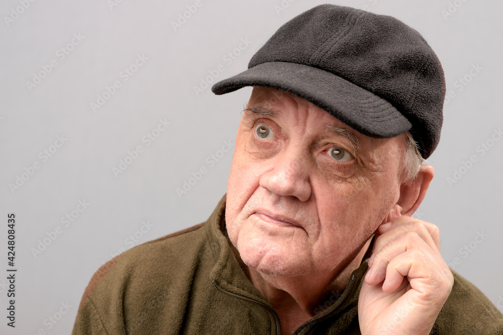 Portrait vieil homme avec casquette regard dubitatif sur fond gris Stock  Photo | Adobe Stock
