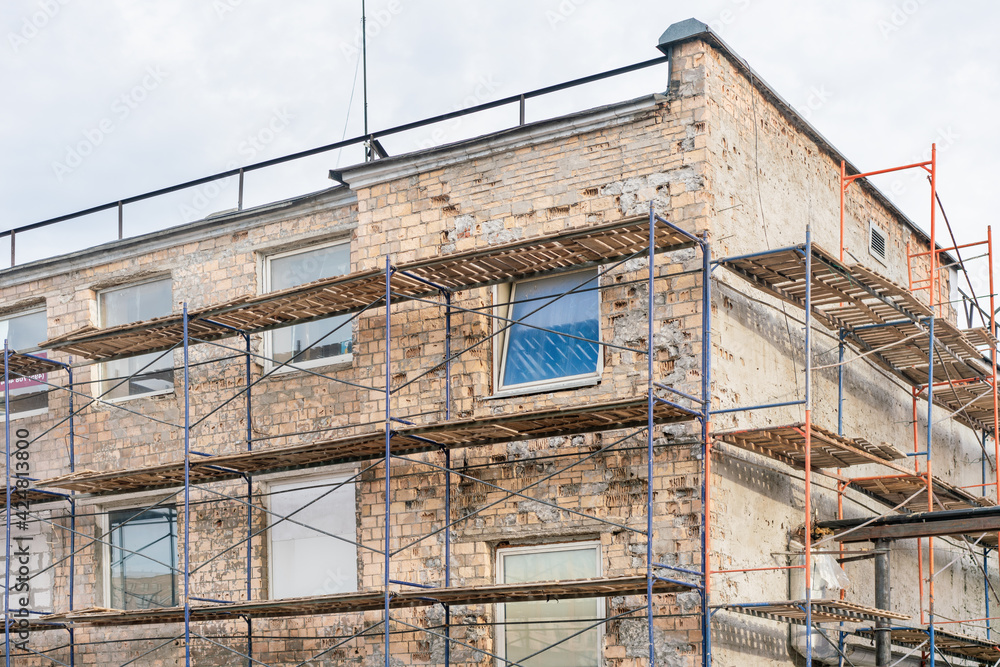 Scaffolding at the facade of the building under repair Scaffolding at the facade of the building under repair