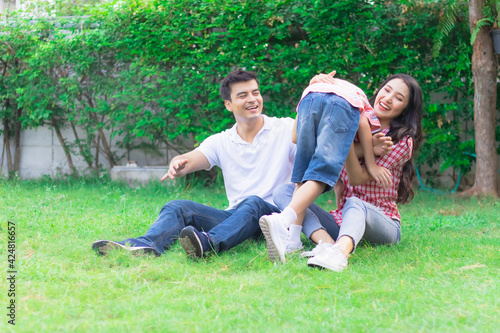 Happy lovely beautiful Asian family father, mother, and son in the backyard