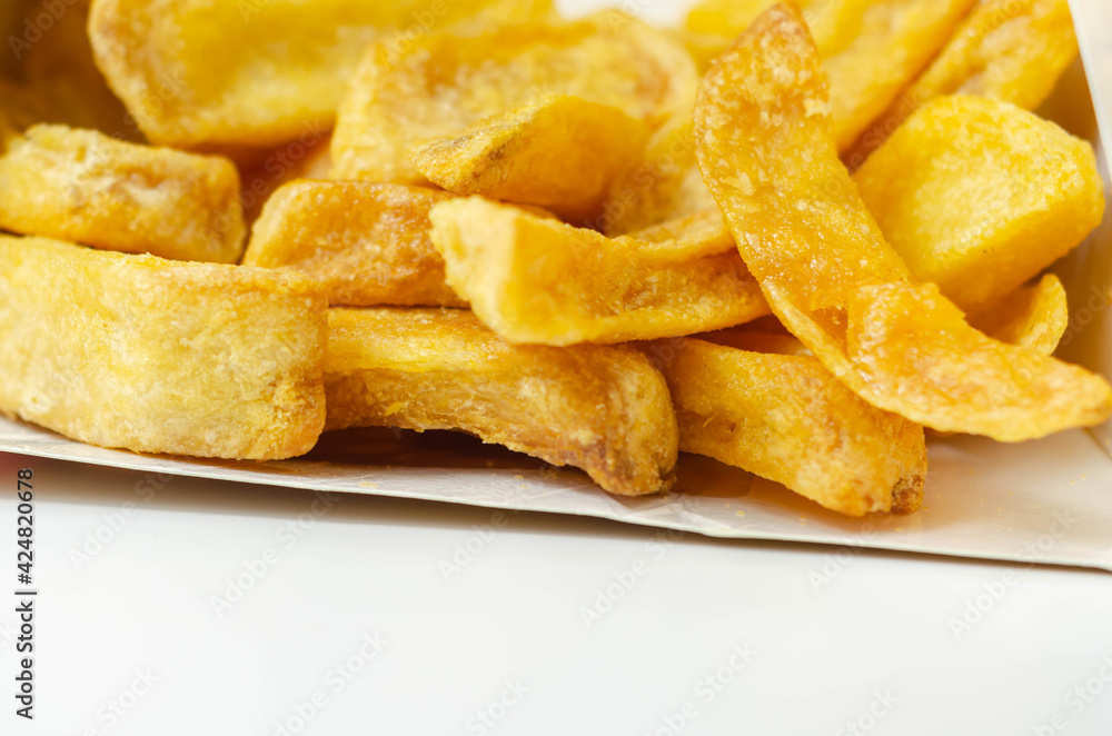 Deep fried and crispy delicious fries in a cardboard box, take away food