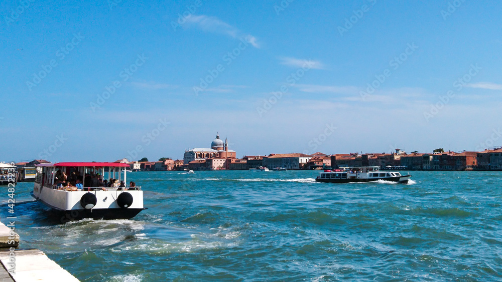  On ferry terminal in Venice, Italy. View on island with Church of San Giorgio Maggiore. Blue waters on sunny summer day. Travel Europe