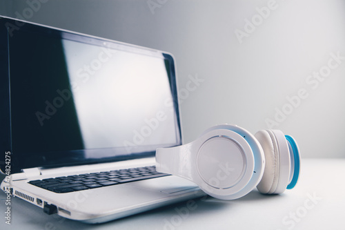 white headphones with computer listening to audio book or music