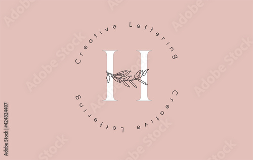 White Letter H Logo with circle lettering design and outline leaves and pastel backgound.
