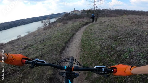 The column of cyclists rides mountain bikes. From the first person.