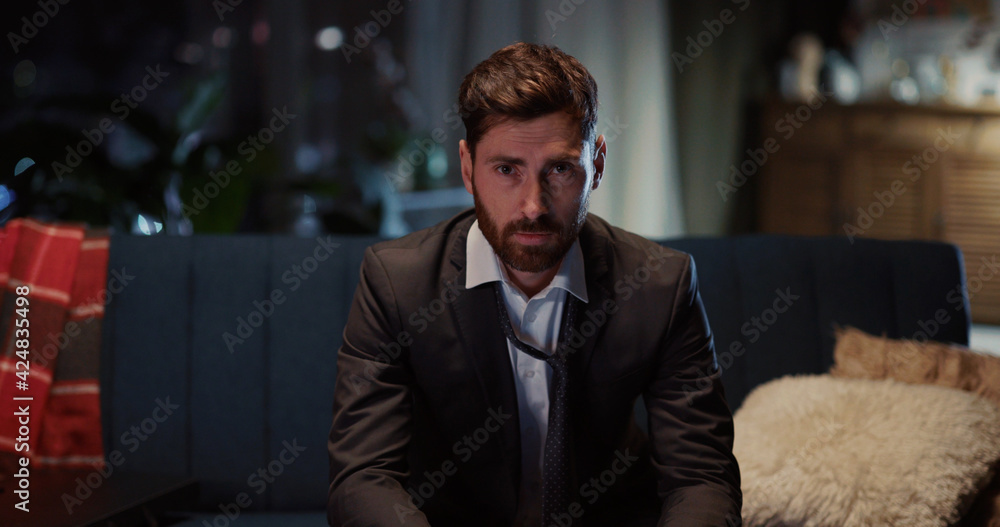 Portrait of caucasian young tired entrepreneur loosening necktie relaxing after hard working day looking into camera. Businessman. Workaholic. Portrait of caucasian young tired entrepreneur loosening necktie relaxing after hard working day looking into camera. Businessman. Workaholic.