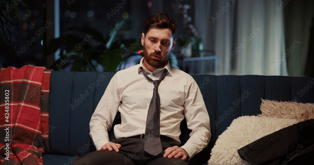 Portrait of caucasian young tired entrepreneur loosening necktie relaxing after hard working day looking into camera. Businessman. Workaholic.