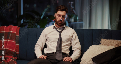 Obraz na płótnie Portrait of caucasian young tired entrepreneur loosening necktie relaxing after hard working day looking into camera. Businessman. Workaholic. w salonie