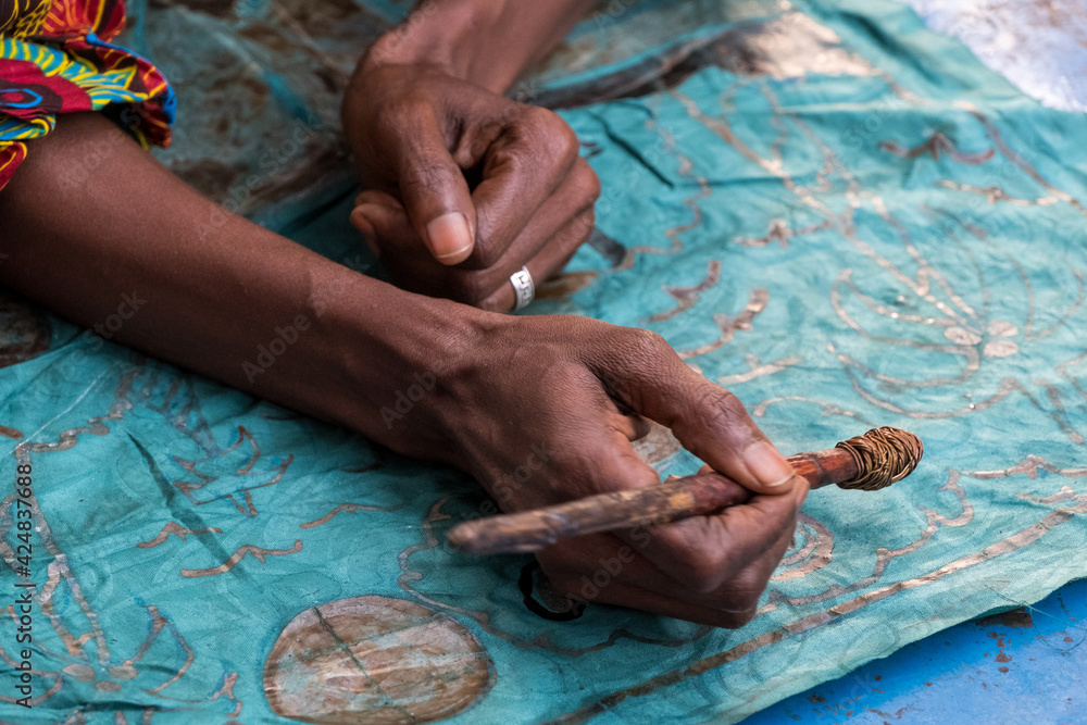 Manos de mujer decorando tela en un pueblo de Gambia Manos de mujer decorando tela en un pueblo de Gambia
