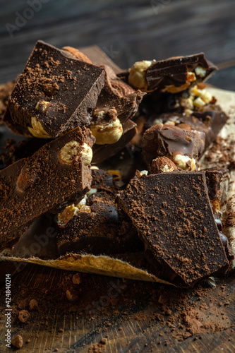 Chopped dark chocolate with hazelnuts on rustic wooden background