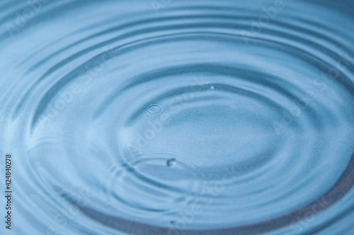 Circles on the blue water from falling raindrops. Close-up