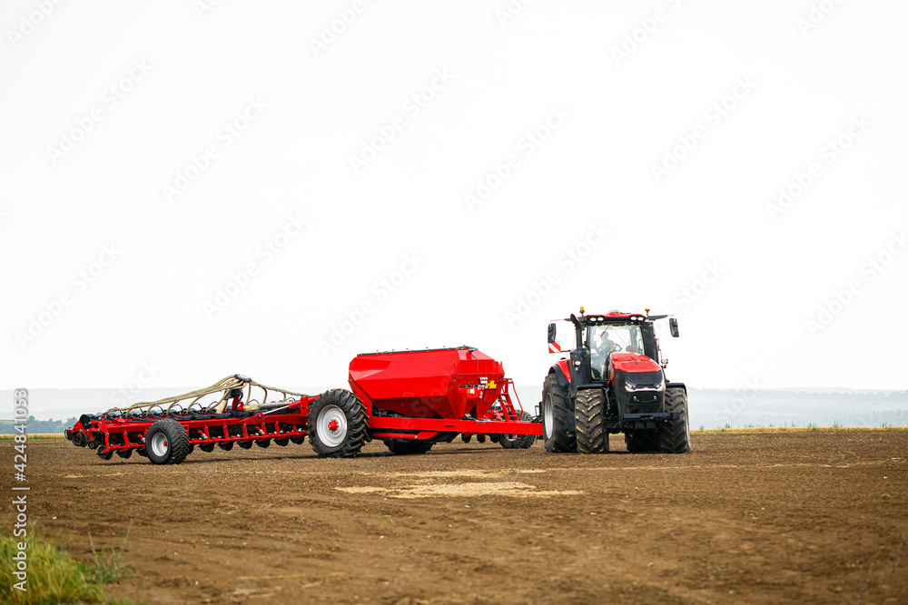 Fototapeta premium Large modern tractor for preparing the field after winter for sowing grain. Agricultural machinery