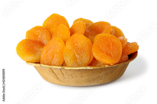Dried apricots in a wooden bowl isolated on white
