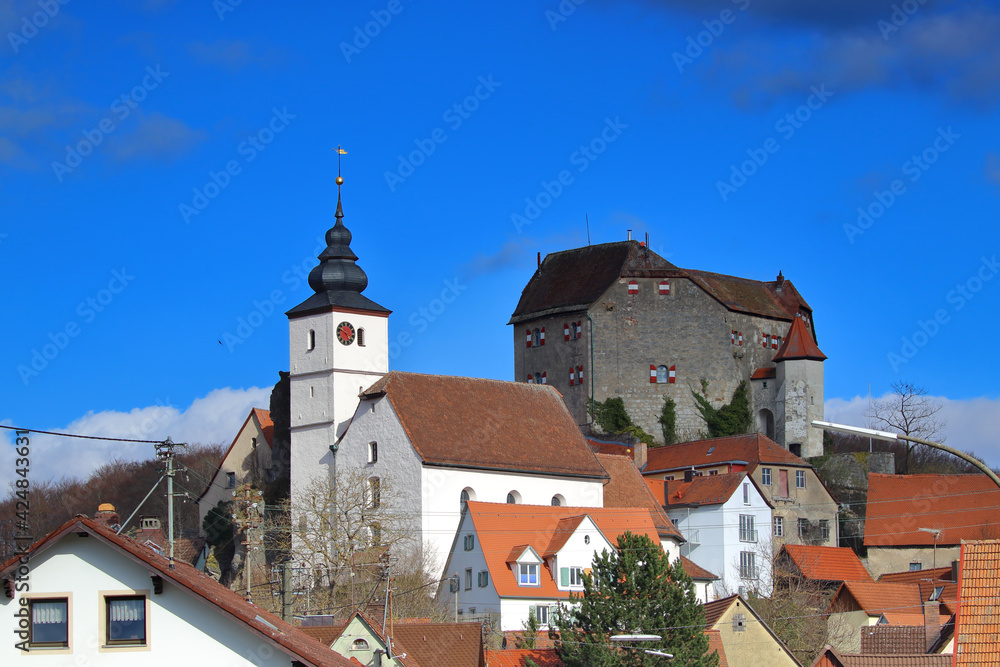 church close to a medieval castle in a village against blue sky church close to a medieval castle in a village against blue sky