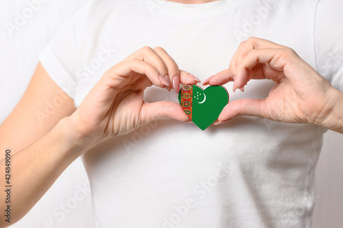 Flag of Turkmenistan in the shape of a heart in the hands of a girl. Love Turkmenistan. The concept of patriotism