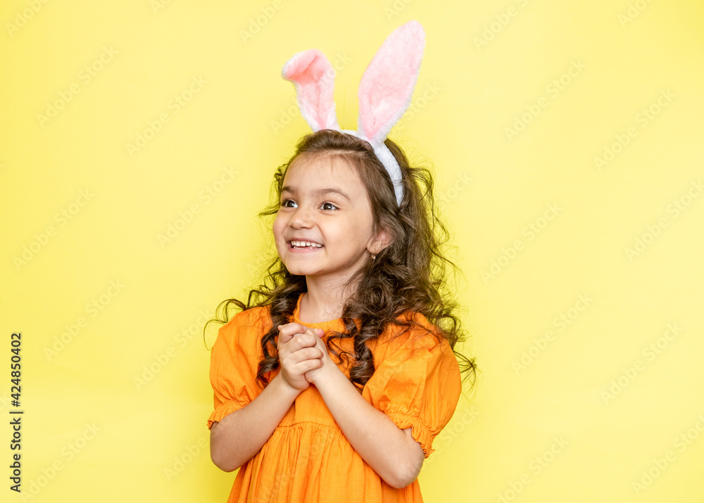 funny happy girl with easter bunny ears on yellow background funny happy girl with easter bunny ears on yellow background