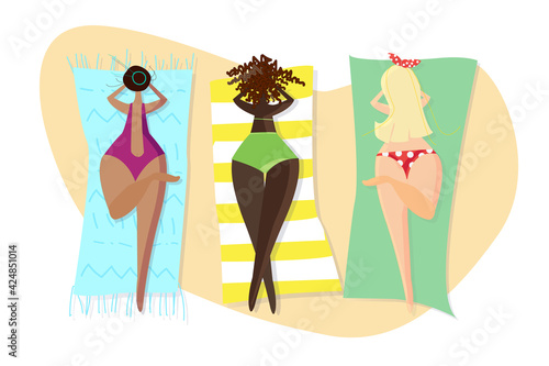 Plus size girls in colored swimsuits sunbathe on towels on the beach