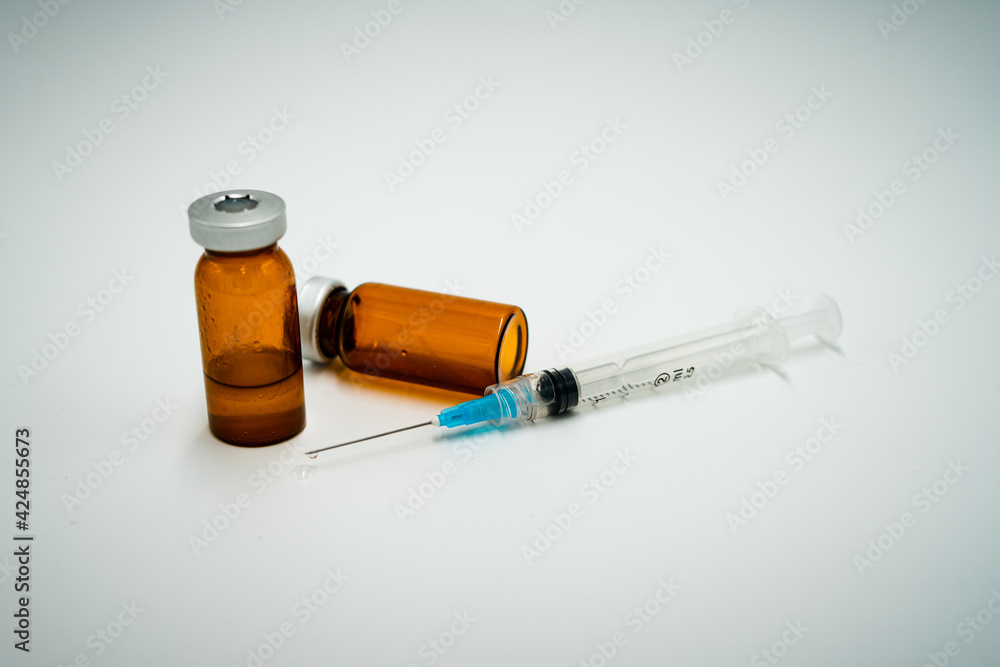 Syringe with multiple vials of injection drugs. Drug drop falls from syringe. Syringe with multiple vials of injection drugs. Drug drop falls from syringe.