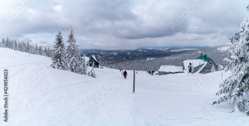 Winter mountain landscape  Poland  Panorama of the Giant Mountains in sunny winter day  from Bia  a Dolina in Szklarska Poreba on Szrenica and Sniezne Kotly  blue sky  white and dark clouds. Snow cover