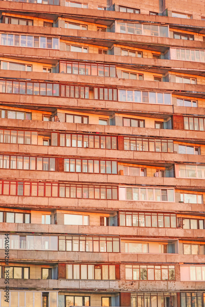windows of a multi-storey building, illuminated by the rays of the setting sun windows of a multi-storey building, illuminated by the rays of the setting sun