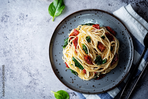 Fototapeta Naklejka Na Ścianę i Meble -  Pasta with dried tomatoes and spinach in a plate