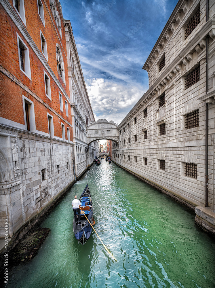 Narrow canal with gondola in Venice, Italy. Architecture and landmark of Venice. Cozy cityscape. Place to travel
