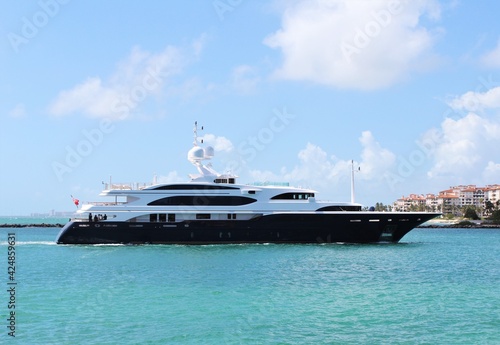 Gigantic big and luxurious yacht sailing through Miami Beach, Florida near South Pointe Pier, nearing the port. Copyspace Advertising.  Investment for millionaires. Faces blurred out