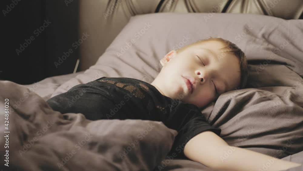 Peaceful baby boy lying on a bed while sleeping. Family, motherhood, love, health and care concept. Peaceful baby boy lying on a bed while sleeping. Family, motherhood, love, health and care concept.