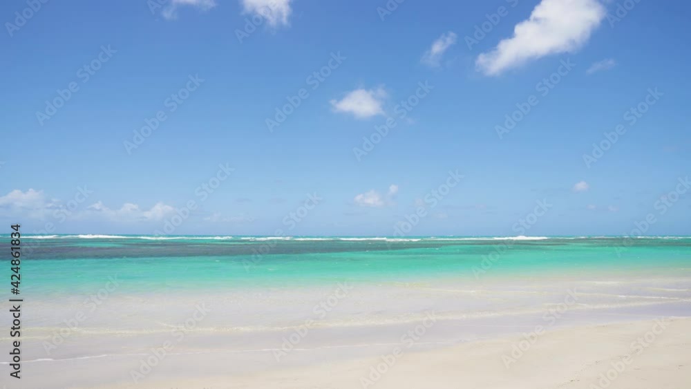 Beautiful Indian Ocean background on a summer sunny day. Transparent turquoise sea waves on the white sand of a paradise tropical beach. Bright colors of the seascape. Beautiful Indian Ocean background on a summer sunny day. Transparent turquoise sea waves on the white sand of a paradise tropical beach. Bright colors of the seascape.