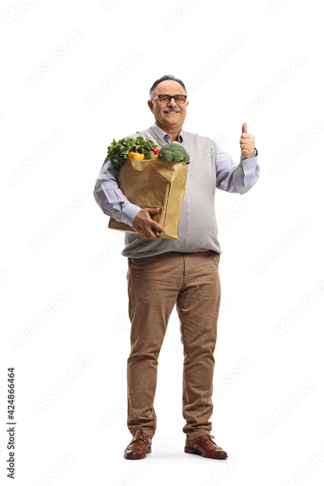 Full length portrait of a cheerful mature man with a grocery bag showing thumbs up Full length portrait of a cheerful mature man with a grocery bag showing thumbs up