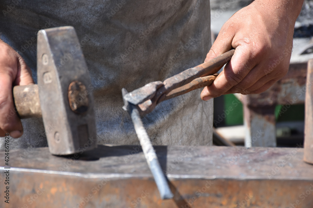 while blacksmith beating iron in old fashion while blacksmith beating iron in old fashion