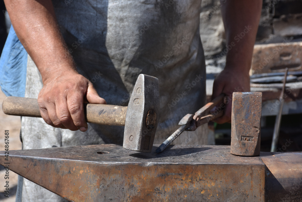 Blacksmith forged ironsmith. traditional hammer beating. Medieval blacksmith. Horseshoe workspace made with the medieval blacksmith method Blacksmith forged ironsmith. traditional hammer beating. Medieval blacksmith. Horseshoe workspace made with the medieval blacksmith method