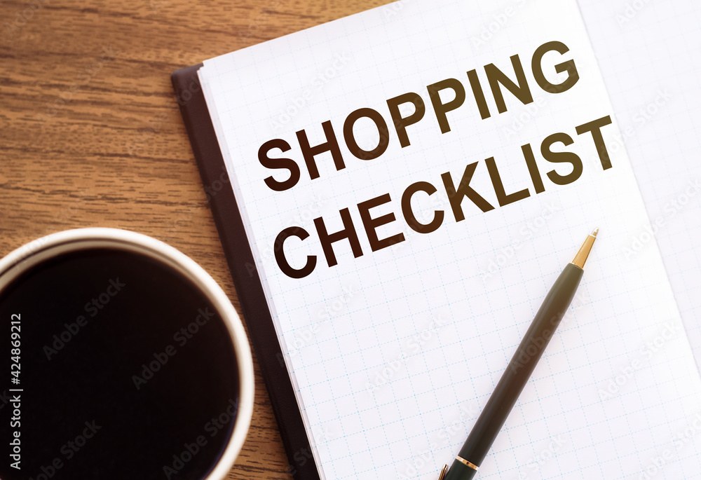Shopping Checklist - text on notepad on wooden desk. Shopping Checklist - text on notepad on wooden desk.