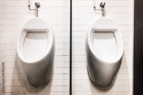 Two wall urinals in public toilets.