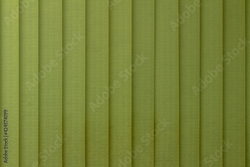 Full frame abstract art design texture background of vertical window blinds in a gradient shade of lime green