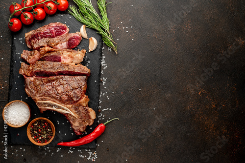 grilled ribeye steak with spices on stone background with copy space for your text