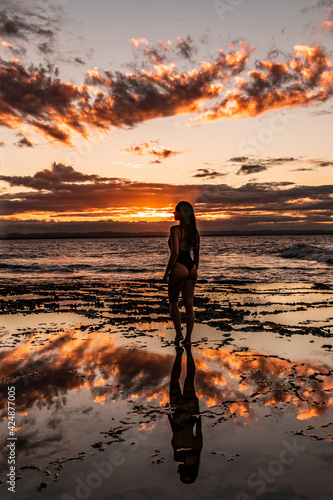 person walking on the beach at sunset