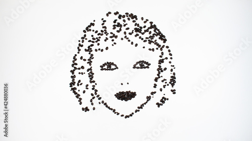 Face of a young smiling woman made from chocolate seeds. Look of a contented woman.