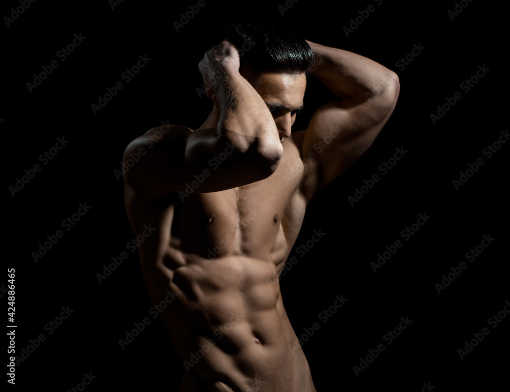Gay body concept. Sexy muscular man. Male bare torso and sexy muscular body of young handsome guy posing in black studio. Gay body concept. Sexy muscular man. Male bare torso and sexy muscular body of young handsome guy posing in black studio.